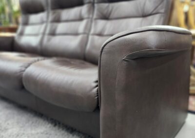 Brown leather sofa on a gray rug.