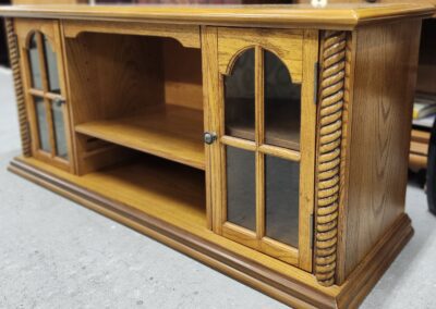 Wooden TV stand with glass doors.