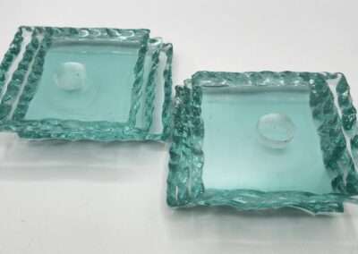 Two square teal glass candle holders.