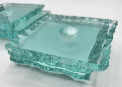 Square glass candle holders with textured edges.