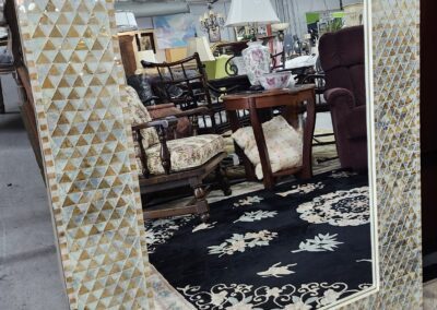 Large decorative mirror with a geometric frame.