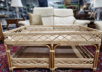 Rattan coffee table on red patterned carpet.