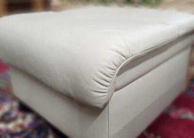 White ottoman on colorful patterned rug.