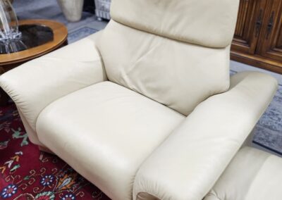 Cream leather recliner on patterned rug.