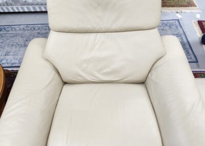 Cream leather armchair on patterned rug.