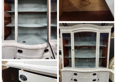 White vintage cabinet with glass doors and shelves.