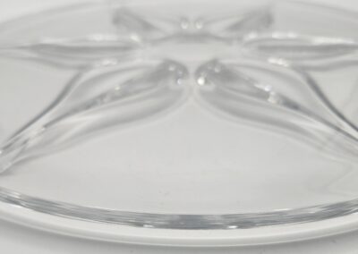 Clear glass plate with decorative grooves.