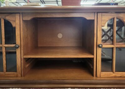 Wooden TV stand with glass doors.