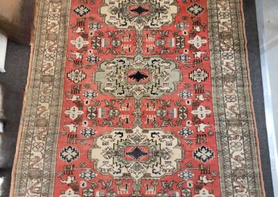 Ornate red and cream patterned area rug.