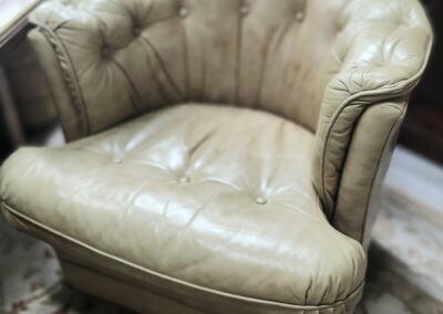 Beige tufted armchair on patterned rug.