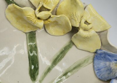 Yellow and blue ceramic flowers with leaves.