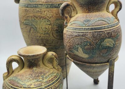 Three decorative ceramic urns with handles.