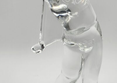 Glass golfer sculpture in swinging pose.