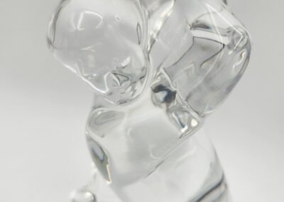 Clear glass sculpture of a standing figure.