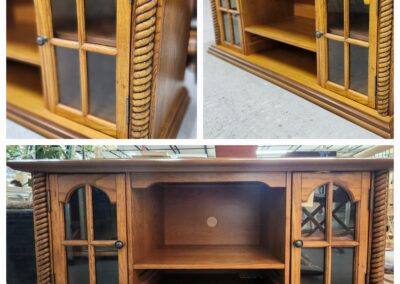 Wooden cabinet with glass doors and shelves.