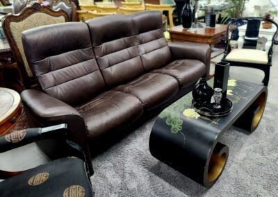 Brown leather sofa with black decorative table.