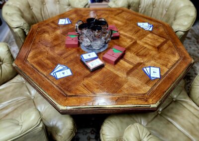 Octagonal table with chairs and card game.