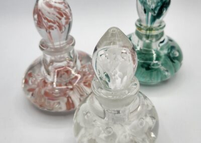 Three decorative glass bottles with stoppers.