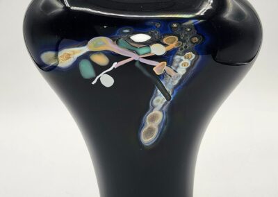 Black vase with colorful abstract design.