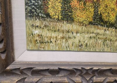 Framed painting of a grassy landscape.