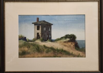 Framed painting of a house by coast.