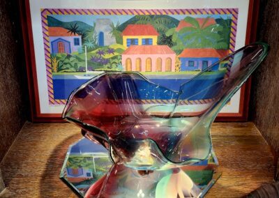 Colorful glass sculpture with framed tropical painting.