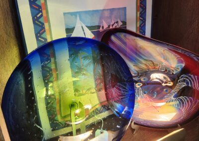 Colorful glass bowls with framed art background.