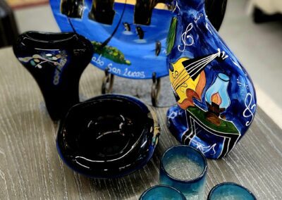 Colorful pottery and glassware on display table.