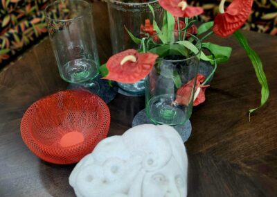 Glass vases, red flowers, white decorative sculpture.