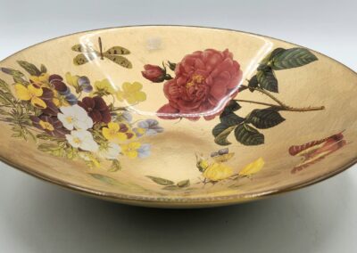 Decorative bowl with floral and insect designs.
