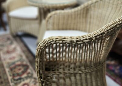 Wicker chairs and table on decorative rug.