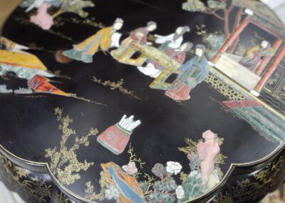 Decorative table with intricate Asian-themed design.