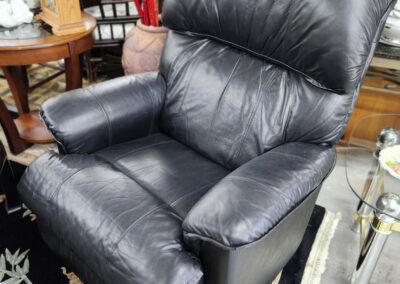 Black leather recliner in a furniture store.