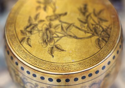 Golden decorative drum with floral patterns.