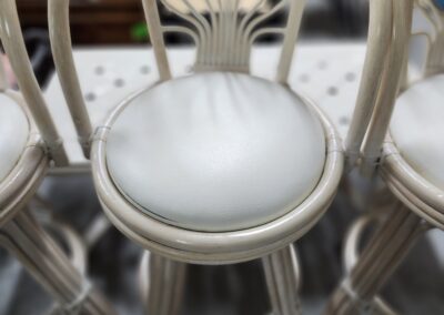 White cushioned barstool with decorative backrest.