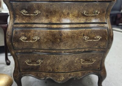Vintage wooden dresser with ornate handles.