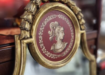Ornate mirror with classical woman's profile.