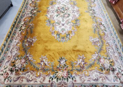 Yellow floral-patterned rug on display.