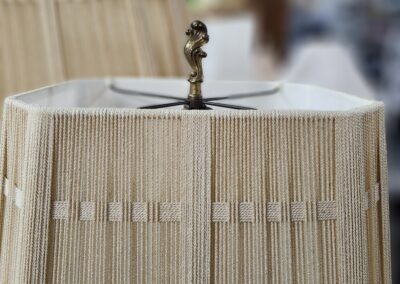 Beige lampshade with decorative finial detail.