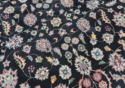 Round floral-patterned carpet with dark background.