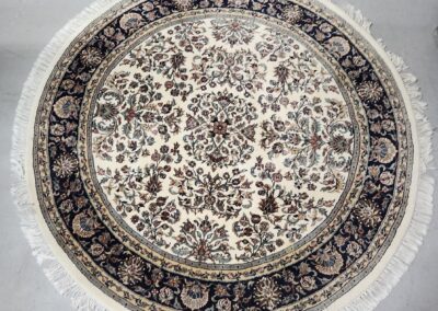 Round ornate rug with intricate floral patterns.