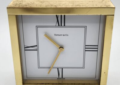 Gold square clock with Roman numerals.