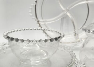 Clear glass tableware with beaded edges.