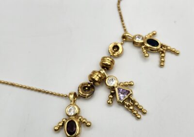 Gold necklace with colorful gemstone pendants.