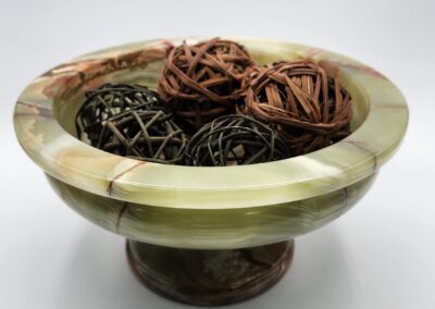 Green bowl with decorative wicker balls.