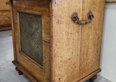 Antique wooden cabinet with ornate metal panel.