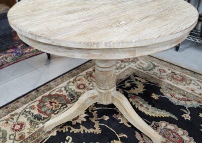 Wooden round table on decorative rug.
