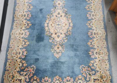 Ornate blue and beige patterned area rug.