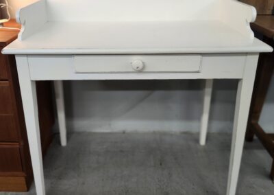 White wooden desk with single drawer.