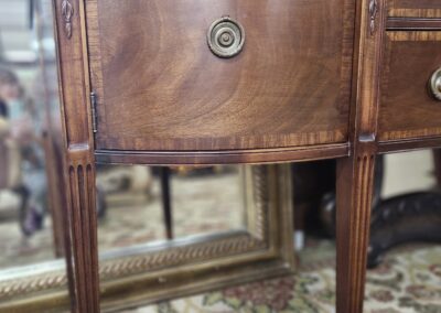 Wooden cabinet with intricate design and legs.